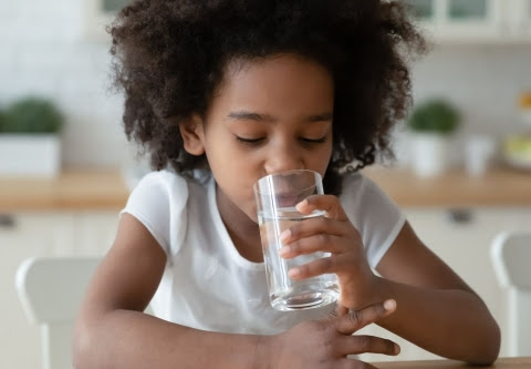 Image of a girl drinking a glass of water. Source: Canva