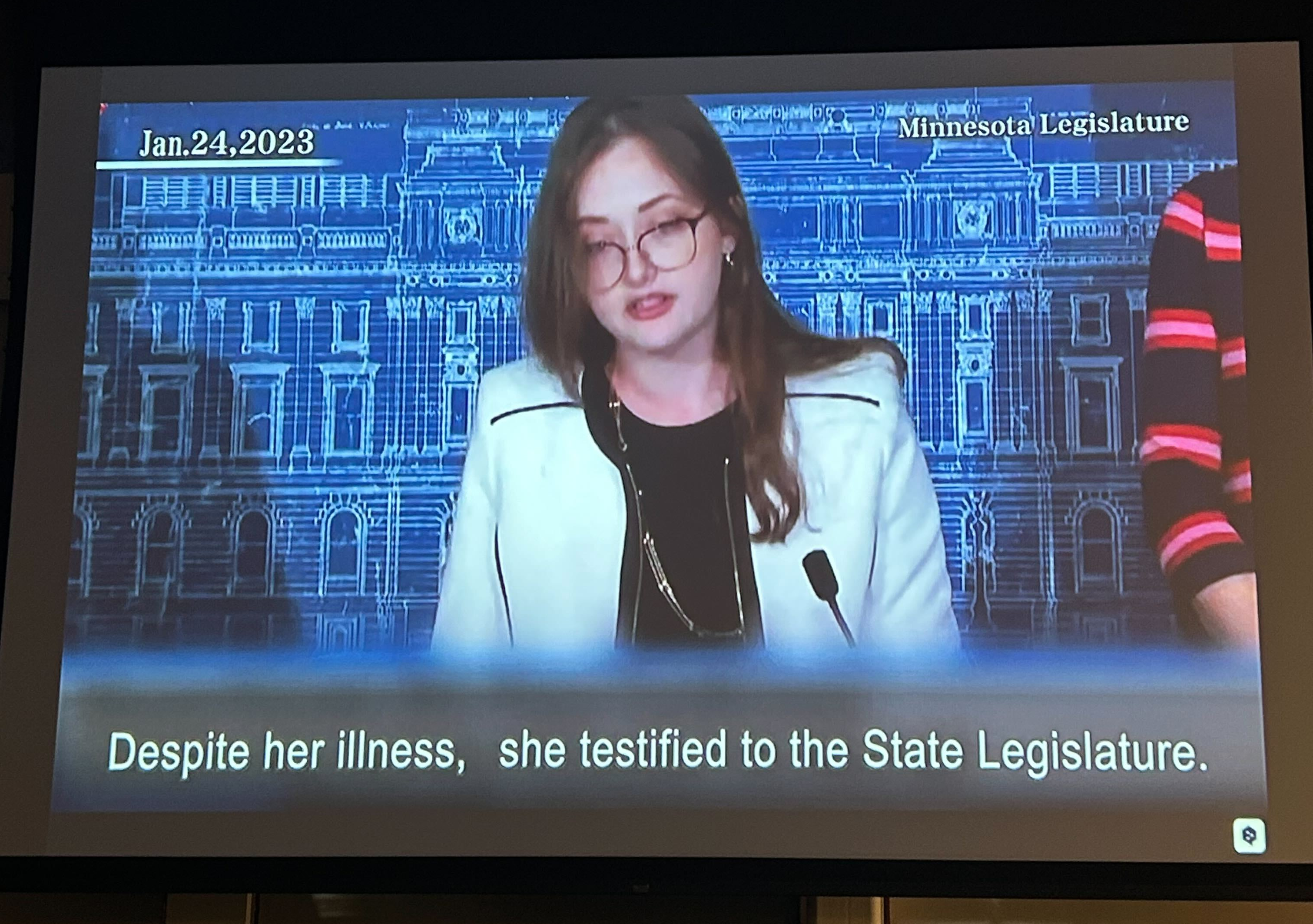 Still from film of Amara Strande, caption: "Despite her illness, she testified to the State Legislature"