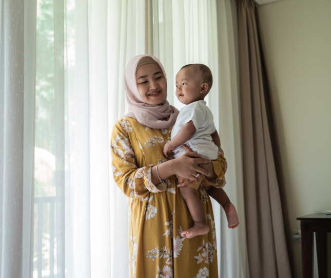 Mother and child alongside window and curtains