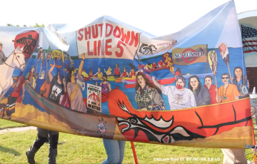 Shut Down Line 5 banner from Wisconsin Protest including "No Tunnel" "Protect Our Water", and Indigenous activists