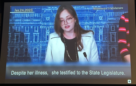 Still from film of Amara Strande, caption: "Despite her illness, she testified to the State Legislature"