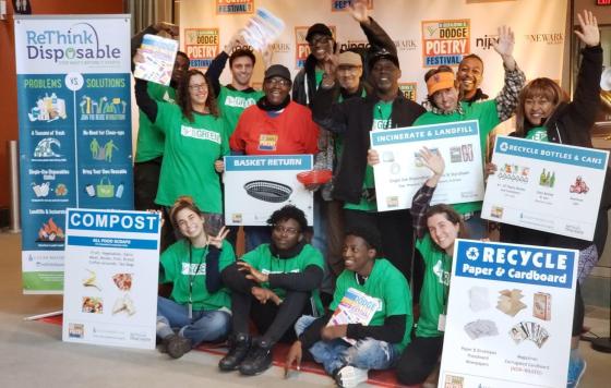 Crowd posing with ReThink Disposable information and recycling/compost educational signs